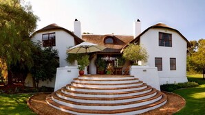 A two-story house with a circular staircase leading to a covered patio. - Marianne Wine Estate (Stellenbosch)