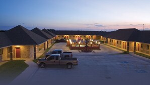 Un motel con diverse camere, un cortile centrale e un'area di parcheggio.