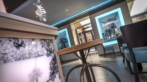 Un interior modern amb una taquilla d'adreça, zona d'estar i obres d'art.