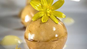 A dessert with a yellow flower garnish on a white plate.