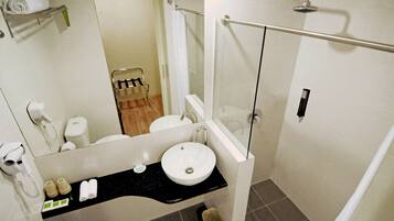 Een moderne badkamer met een wastafel, spiegel en douche.