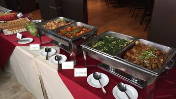 A buffet with various dishes, including a section for Asian cuisine, and multiple serving utensils.