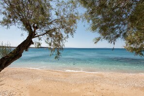 Na praia, espreguiçadeiras, guarda-sóis, toalhas de praia 