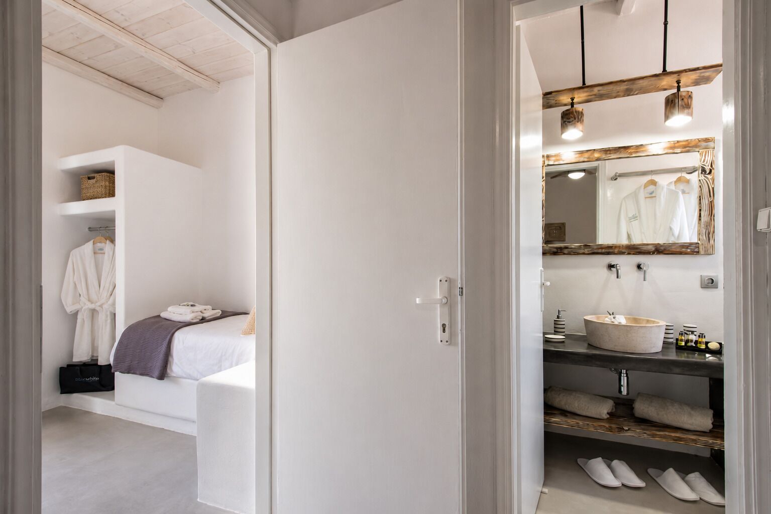 A modern bathroom with a large mirror, a round sink, and a towel rack.
