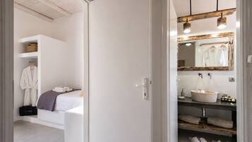 A modern bathroom with a large mirror, a round sink, and a towel rack.