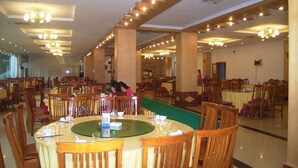 A spacious dining area with multiple tables and chairs, high ceilings with recessed lighting, and large windows allowing natural light. - Fengyuyan Hotel (Guilin)