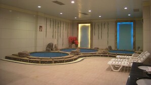 A spa area with multiple hot tubs, lounge chairs, and a reception desk. - Fengyuyan Hotel (Guilin)
