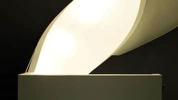 A modern, illuminated architectural feature with a curved design, likely part of a building's interior structure.
