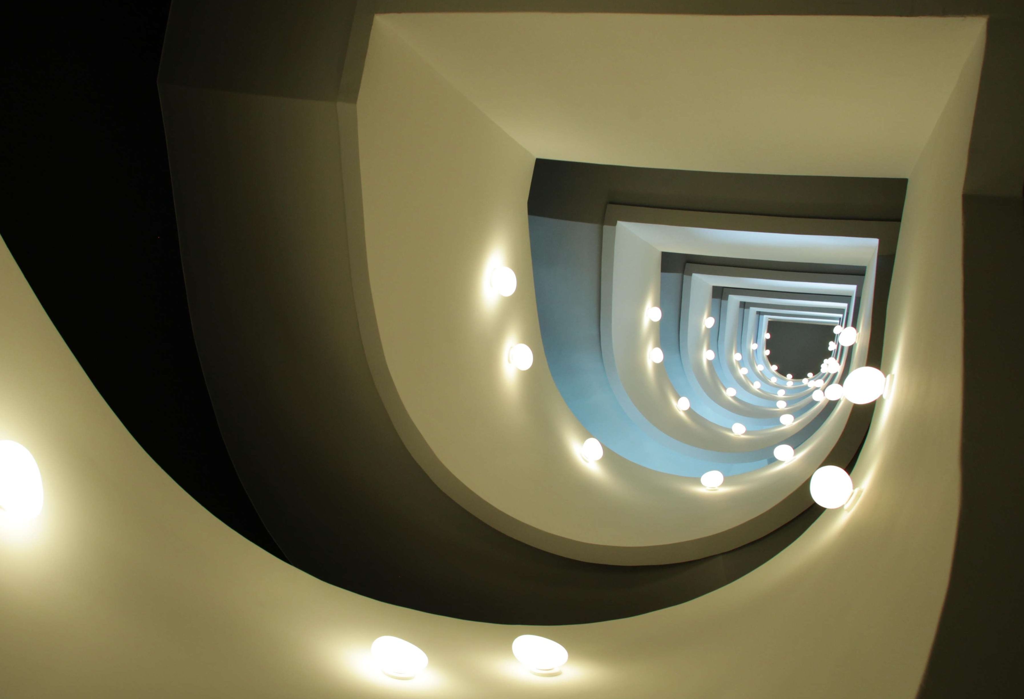 A spiral staircase with circular lighting fixtures.
