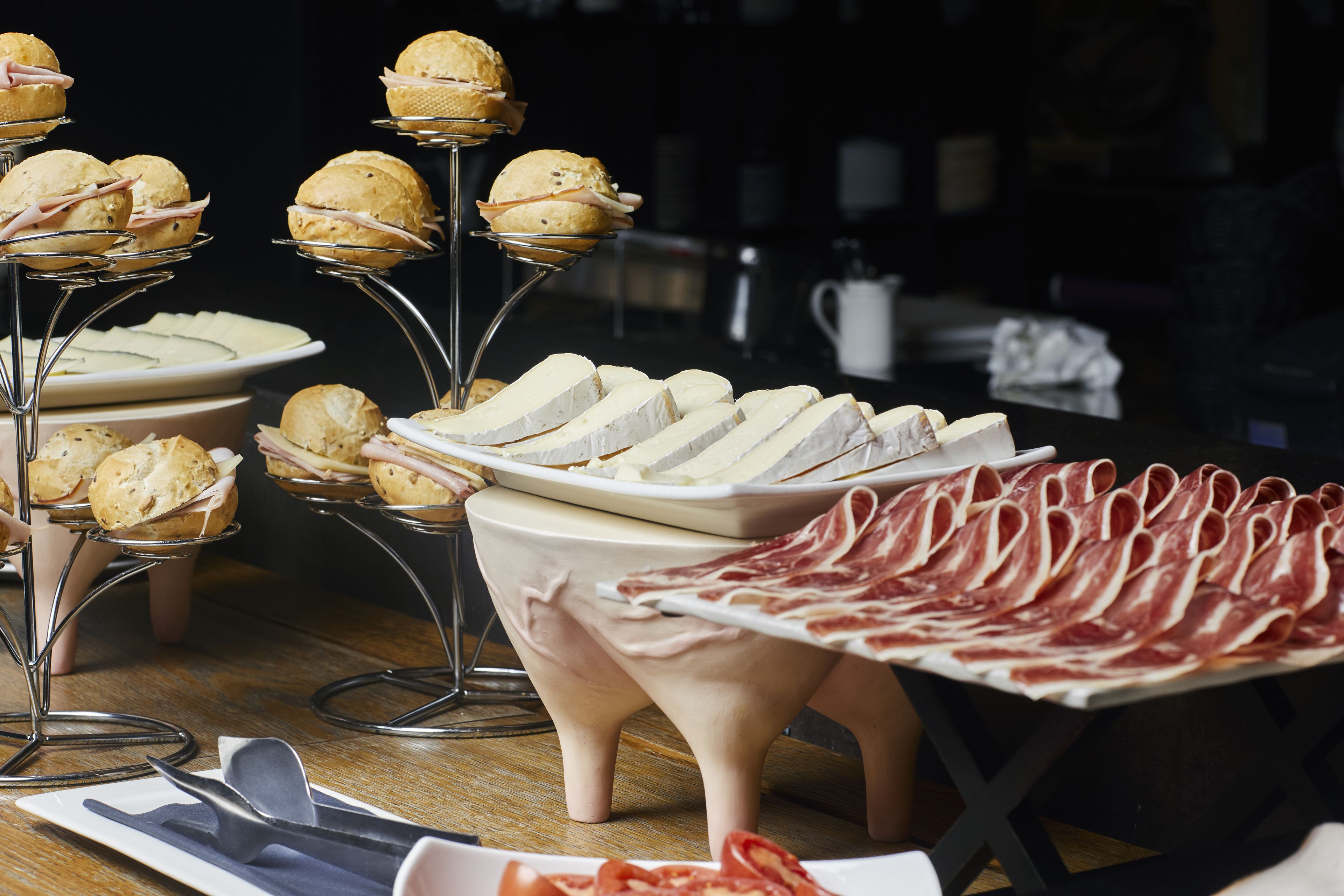 A buffet table with various food items including pastries, cheese, and cured meats.