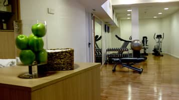 Een fitnessruimte met trainingsapparatuur, een houten receptiebalie en een klok aan de muur.