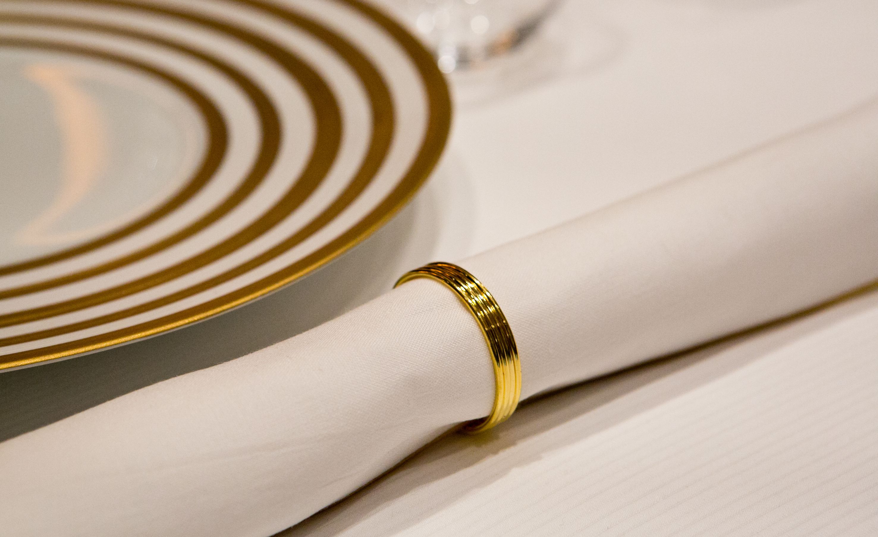 A white fabric with a gold band, possibly a piece of clothing or accessory.