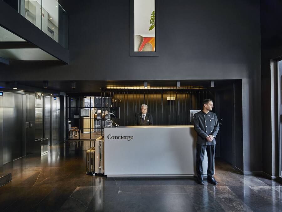 Een moderne hotelentree met een receptiebalie met de tekst