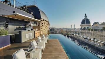 Un bar en la azotea con piscina y vistas a la ciudad.