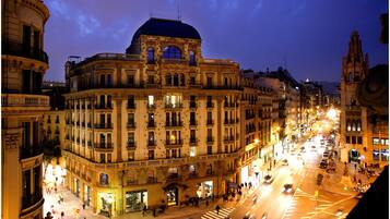 A historic building with a dome and classical architecture, located on a busy street with pedestrians and vehicles.