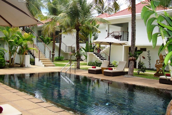 Alberca al aire libre y sombrillas en la alberca