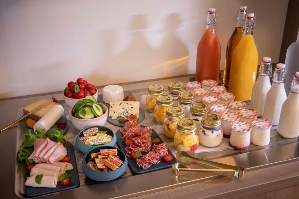 A buffet table with various food items including meats, cheeses, and condiments.