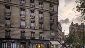 Un hôtel à plusieurs étages doté de balcons, d’un restaurant situé au rez-de-chaussée et d’une entrée bien visible.