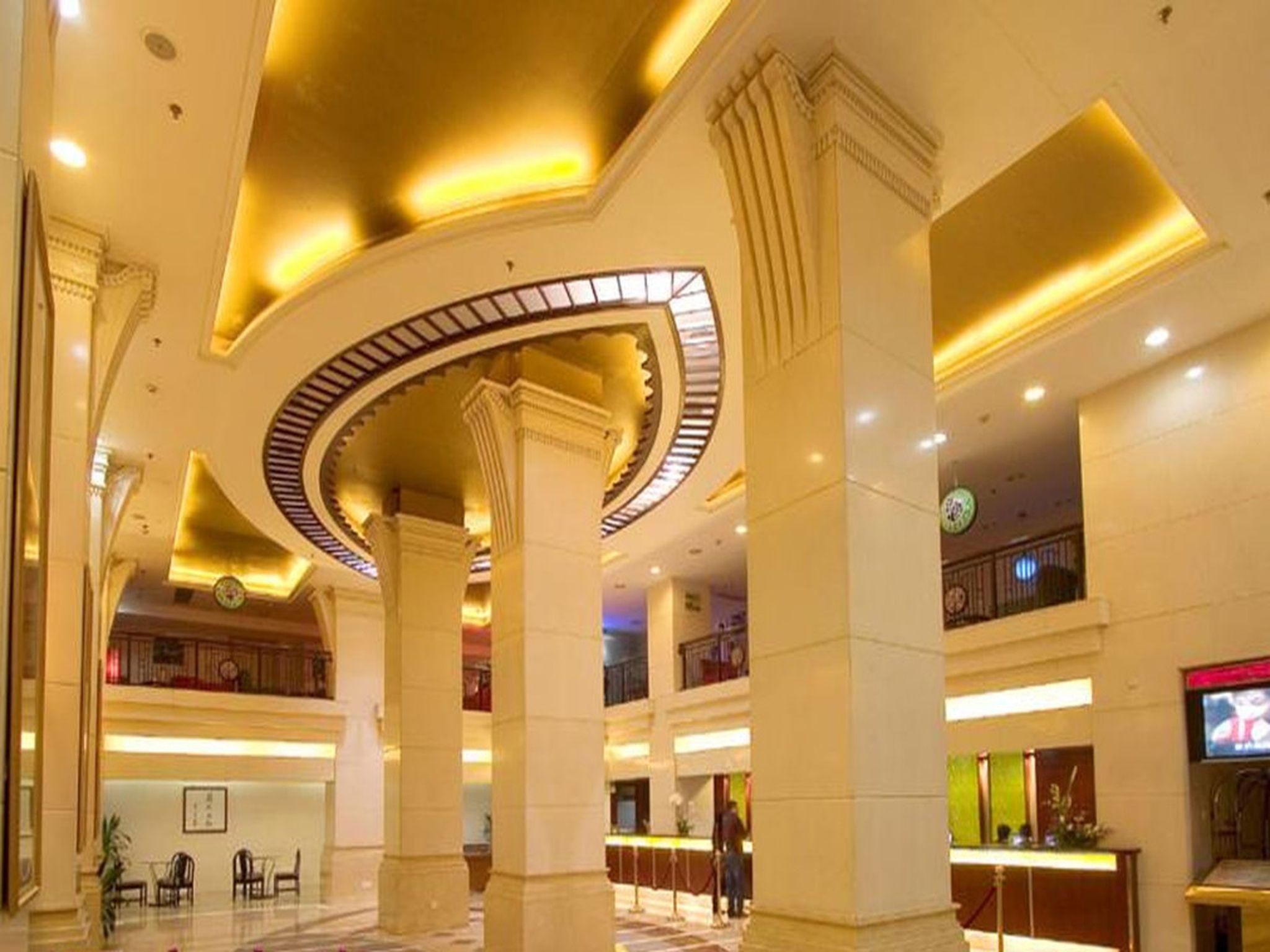A spacious lobby with high ceilings, large columns, and a central circular skylight.