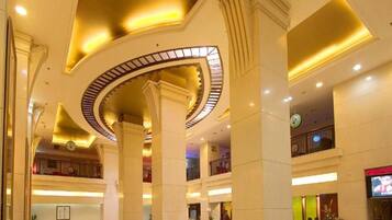 A spacious lobby with high ceilings, large columns, and a central circular skylight.