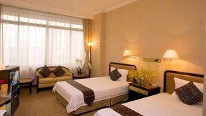A hotel room with two beds, a sofa, a TV, and a desk with a lamp. - Aiqun Hotel Guangzhou (Guangzhou)