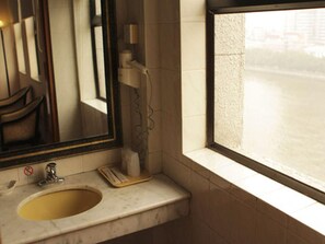 A bathroom with a sink, mirror, and window. - Aiqun Hotel Guangzhou (Guangzhou)