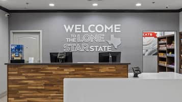 A reception desk with a welcome sign for Lone Star State, a phone, and a shelf with snacks.