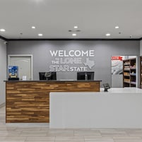 Una recepción con un cartel de bienvenida para Lone Star State, un teléfono y una estantería con aperitivos.