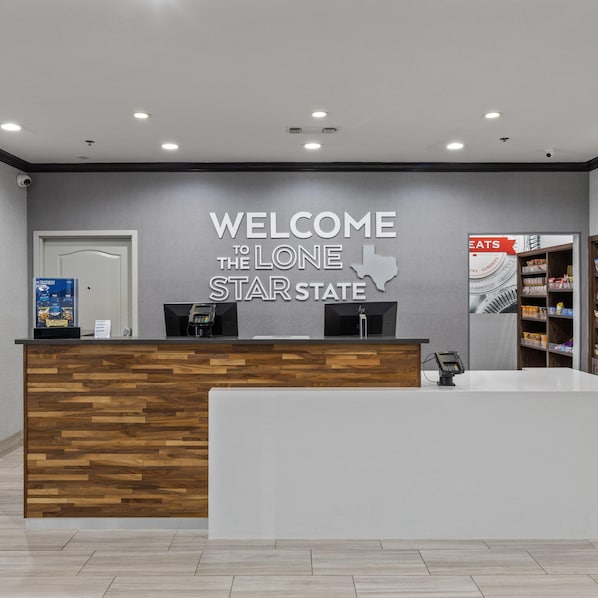 A reception desk with a welcome sign for Lone Star State, a phone, and a shelf with snacks. - Hampton Inn & Suites Denison (Denison)