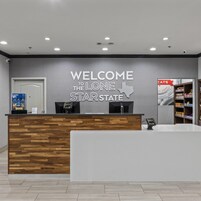 A reception desk with a welcome sign for Lone Star State, a phone, and a shelf with snacks.