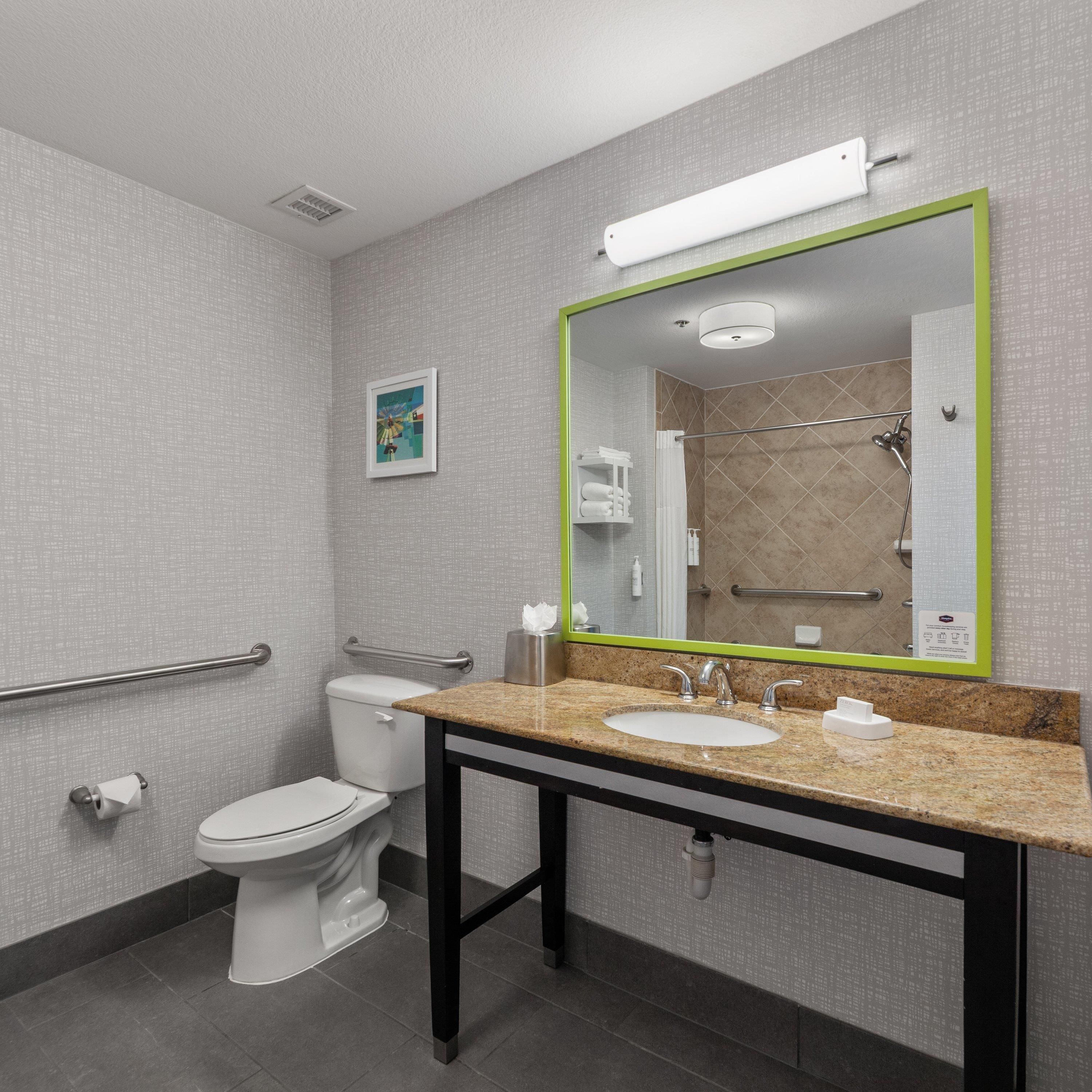 A modern bathroom with a toilet, sink, and shower area.