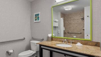 A modern bathroom with a toilet, sink, and shower area.