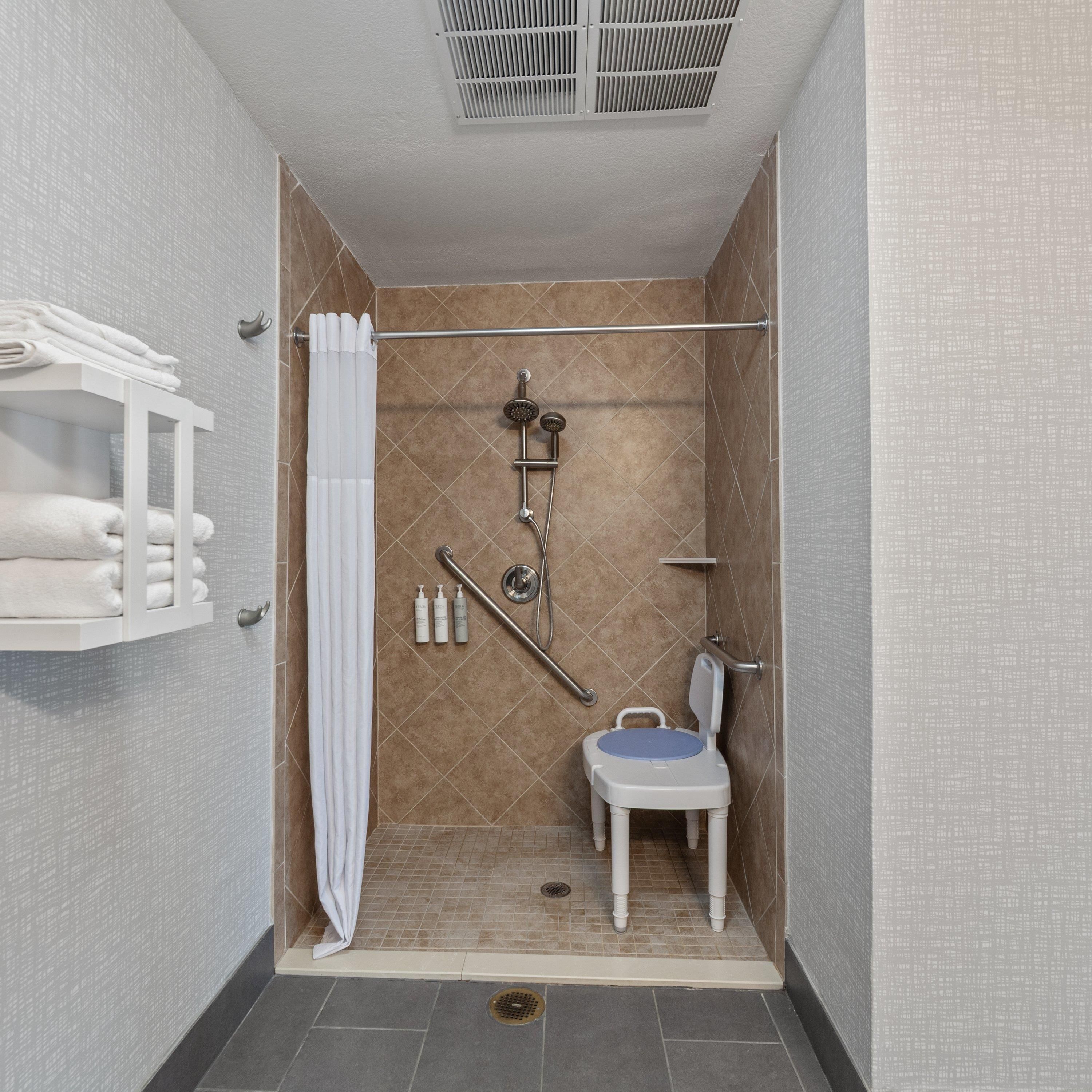 Un baño pequeño y moderno con ducha, inodoro y un perchero para toallas.