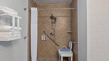 A small, modern bathroom with a shower, toilet, and a towel rack.
