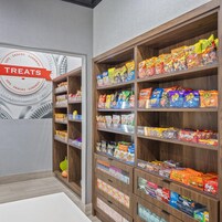 Een stelling met verschillende verpakte snacks en een bordje dat de afdeling aangeeft.
