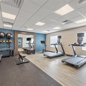 A gym with treadmills, a weight bench, kettlebells, and exercise balls. - Hampton Inn & Suites Denison (Denison)