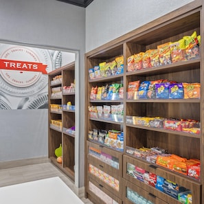 A snack aisle with various packaged snacks and a sign indicating the section. - Hampton Inn & Suites Denison (Denison)