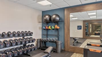 A gym with exercise equipment, including dumbbells, kettlebells, and exercise balls.