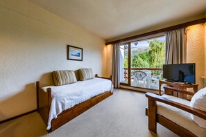 A bedroom with a bed, a TV, and a balcony with a view. - Soft Catedral (San Carlos de Bariloche)