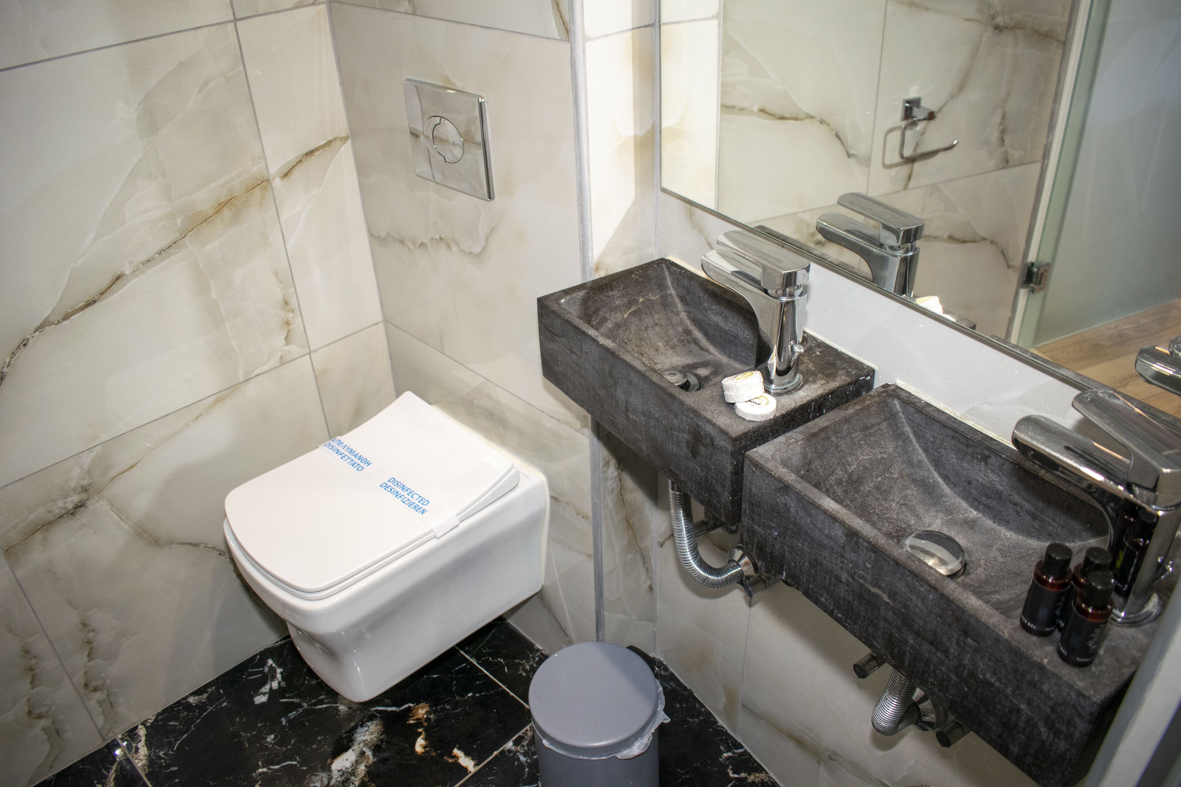 Ein Badezimmer mit Toilette, Waschbecken und Spiegel.