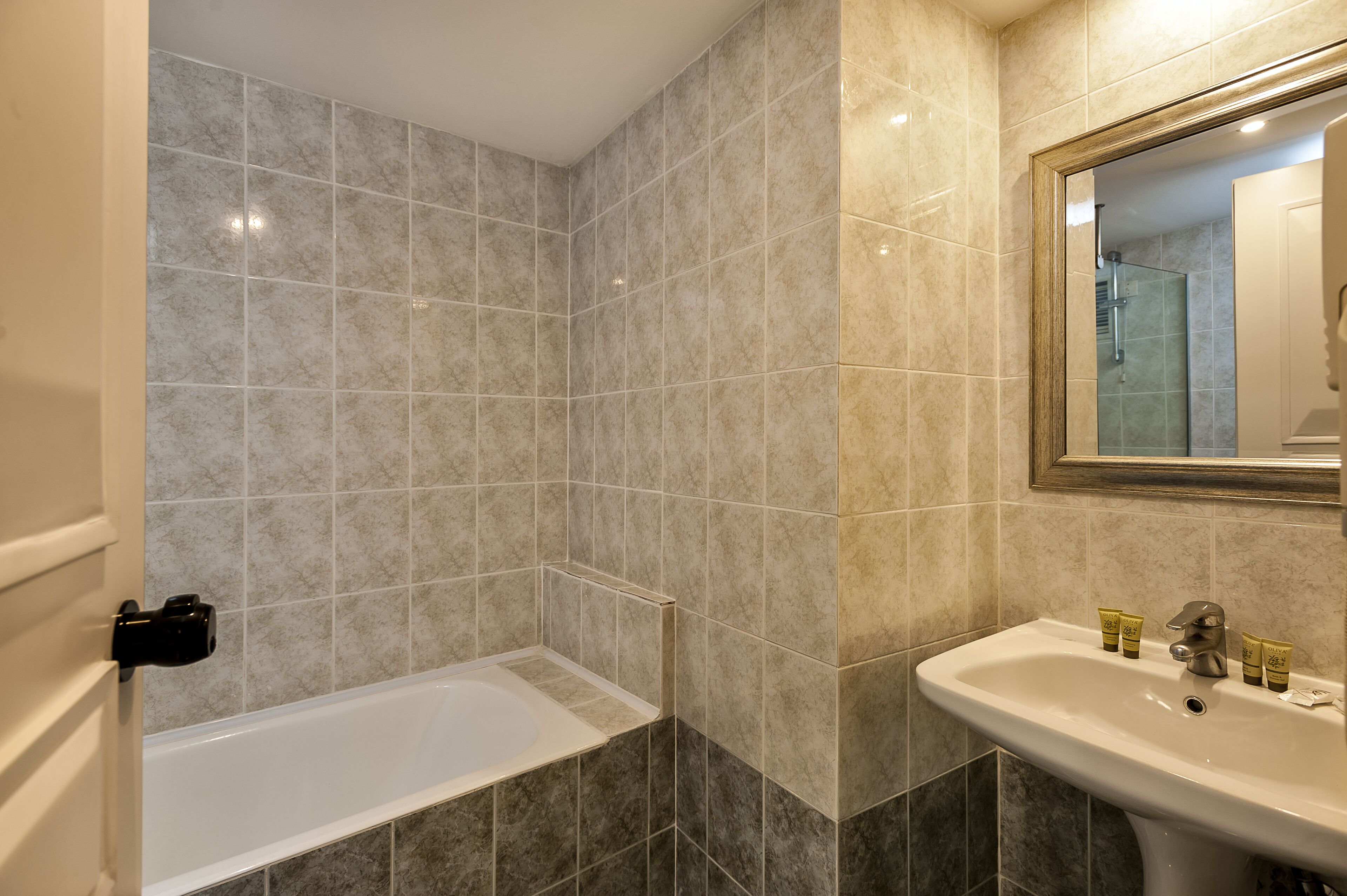 Une salle de bain avec une baignoire, un lavabo et un miroir.