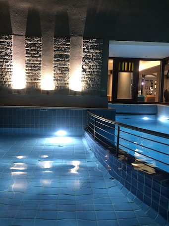 Una piscina al aire libre, sillones reclinables de piscina