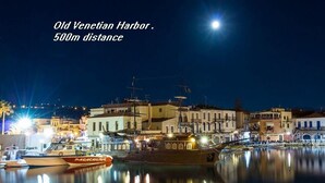 Una vista nocturna del puerto veneciano histórico, con barcos amarrados y edificios a lo largo de la costa.