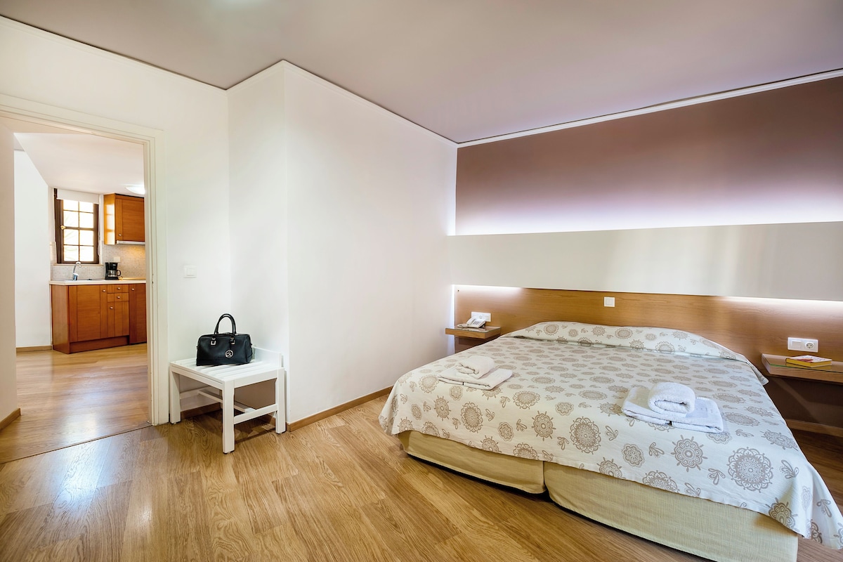 Une chambre d’hôtel avec un lit, une table de chevet et une vue sur la cuisine.