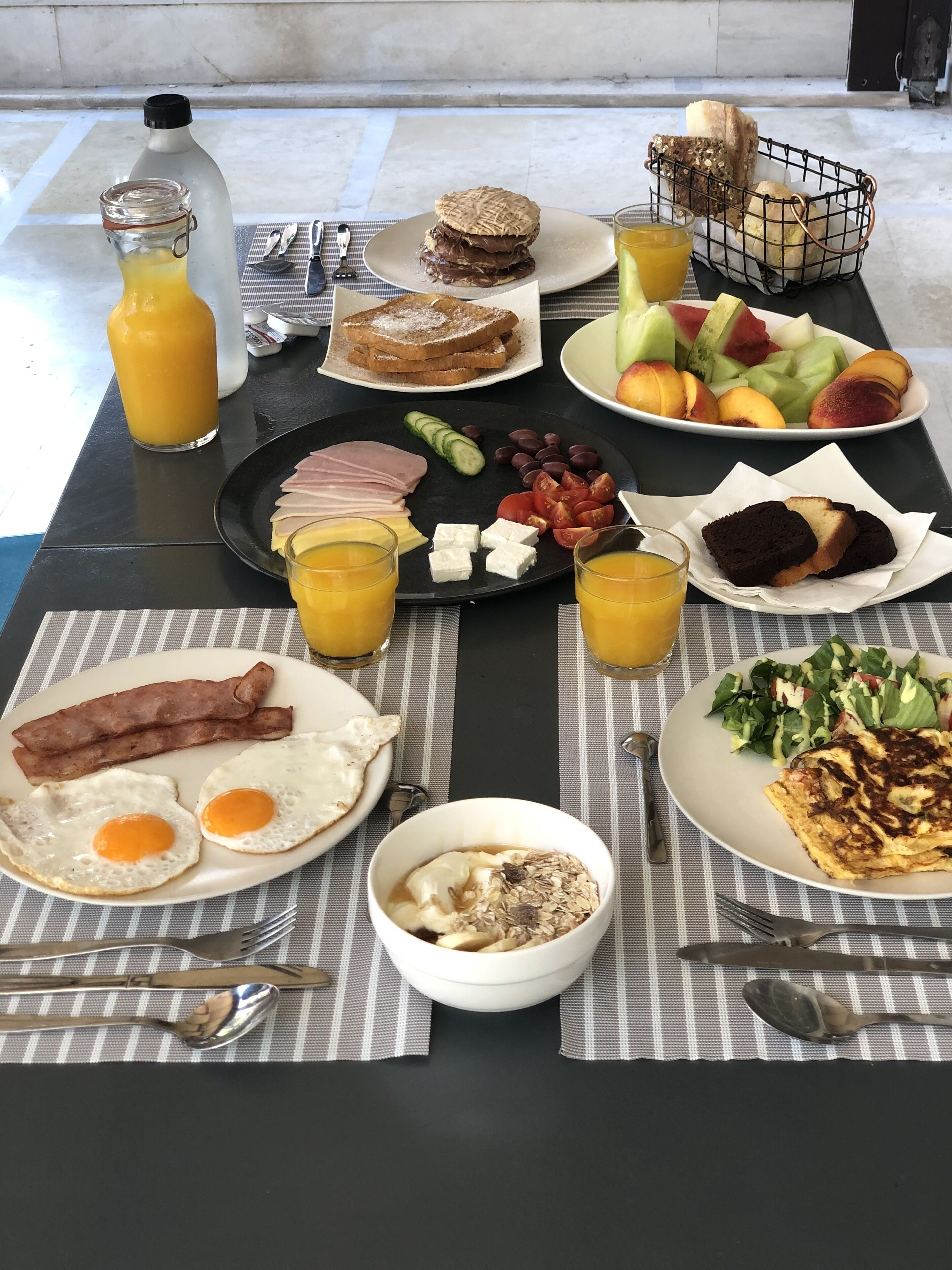 Un assortiment de produits alimentaires et de boissons est présenté sur une table pour le petit-déjeuner.
