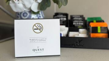 Señal blanca con el símbolo de prohibido fumar y texto que agradece a los huéspedes no fumar en los apartamentos.