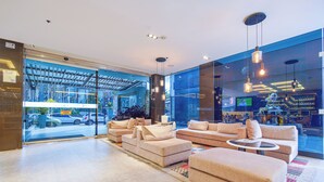 A modern lobby with a seating area, large windows, and a visible outdoor parking area. - One Sixteen Hotel (Bogotá)