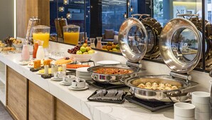 A buffet with various food items and drinks, including fruits, cereals, and beverages. - One Sixteen Hotel (Bogotá)
