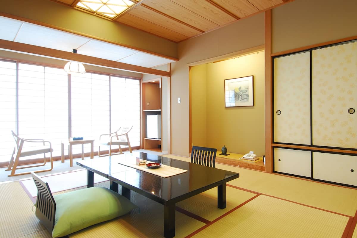 A traditional Japanese room with tatami flooring, a low table, and shoji screens.