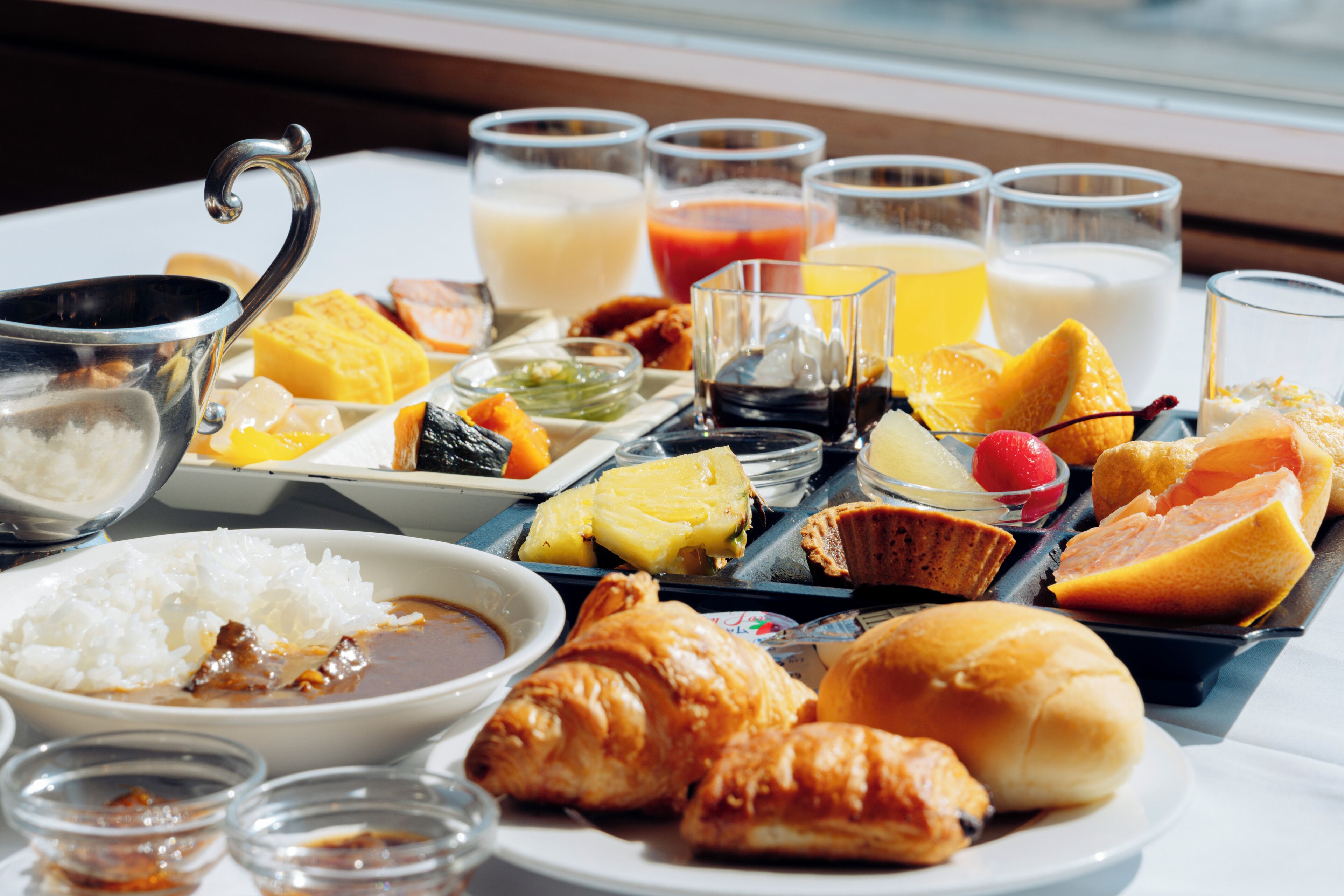A breakfast spread with various dishes and drinks on a table.